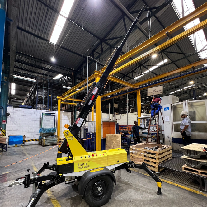 AMX em pátio industrial próximo à ponte rolante, pronto para trabalhos de manutenção.