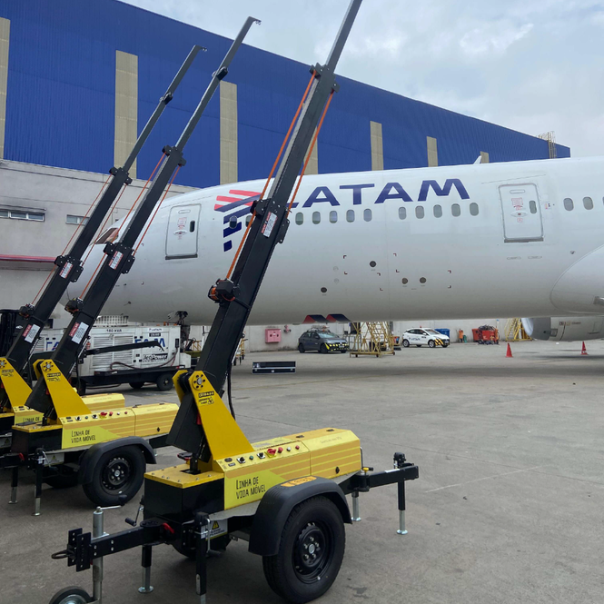 Unidades AMX em hangar de aeroporto com avião LATAM ao fundo, demonstrando versatilidade.