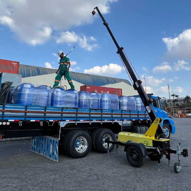 Transporte do AMX na carroceria de caminhão com tanques de água, facilitando logística.