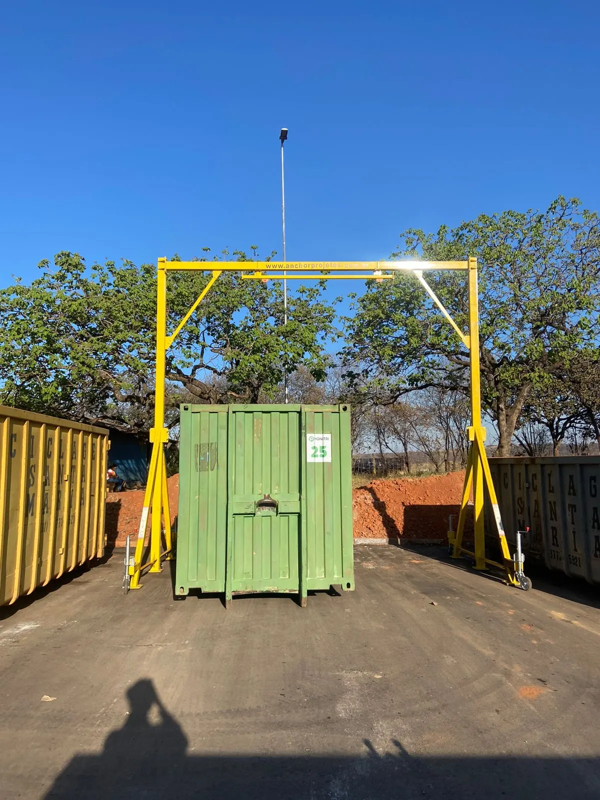 Pórtico de izaje móvil amarillo fabricado por Anchor operando con contenedor