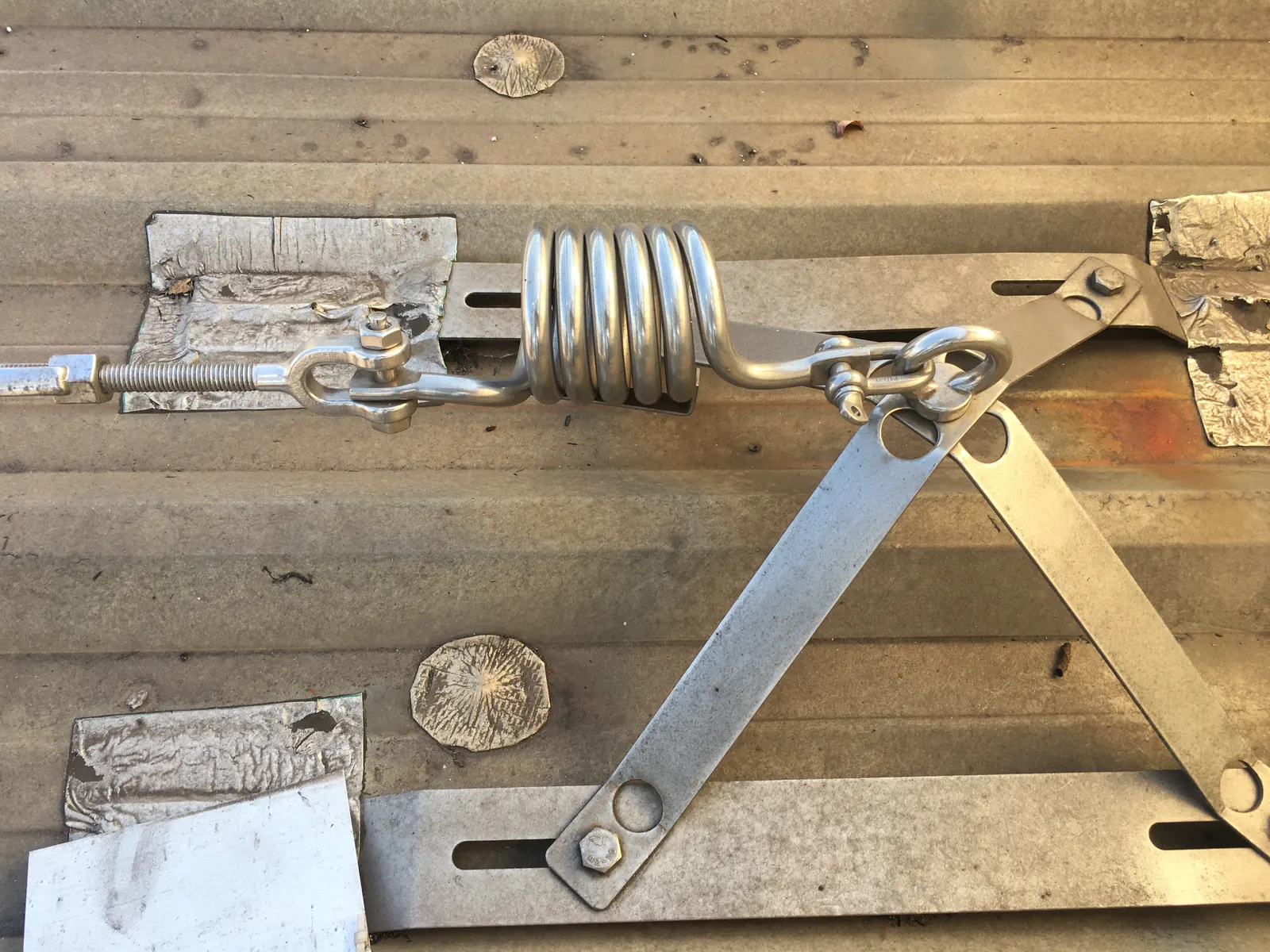 Spring energy absorber and stainless steel spider plate on the roof sheet