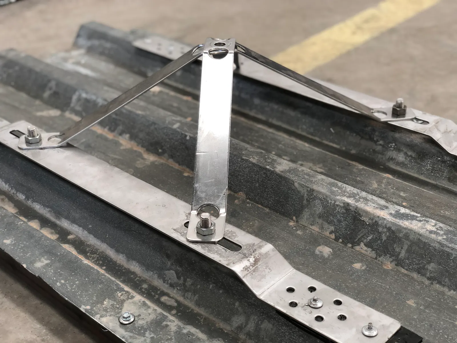 Stainless steel spider fixing plate mounted on a metal roof sheet