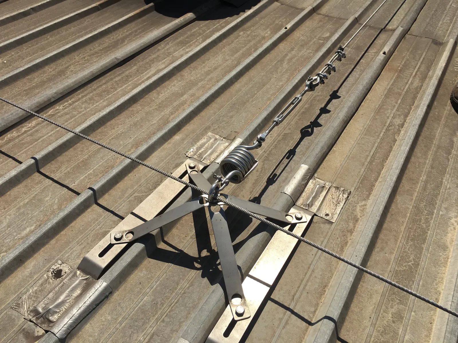Tensioned stainless steel lifeline cable over a standing-seam roof